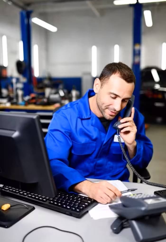A mechanic working under the bonnet of a car in an independent garage
